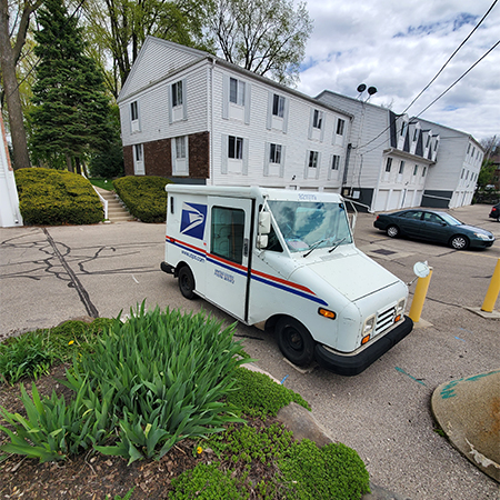 USPS Delivery Truck parked while the driver deliveres important news and packages to the surrounding homes.